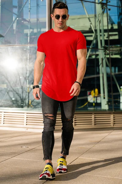 Ein Mann trägt ein leuchtend rotes T-Shirt mit einem Glasgebäude im Hintergrund.