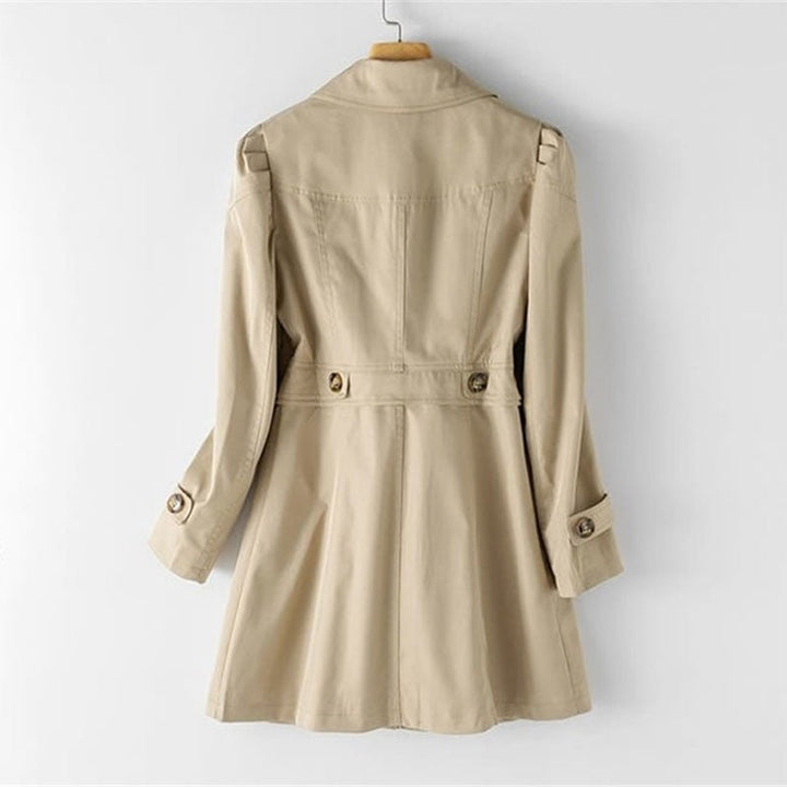 Rückansicht eines khakifarbenen Trenchcoats, der auf einem Kleiderbügel hängt, mit taillierter Taille und Knopfdetails an den Ärmeln.