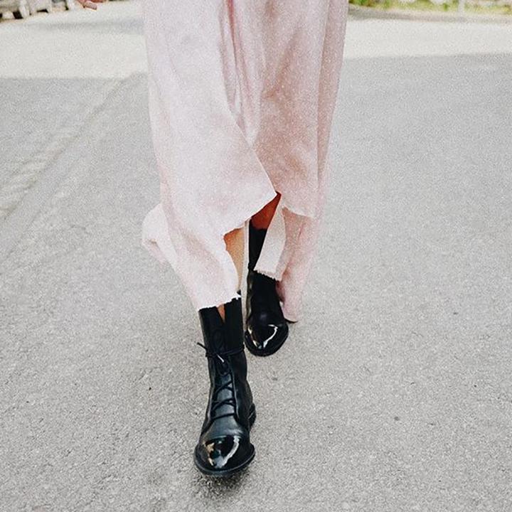 Nahaufnahme einer Frau, die beim Gehen schwarze Vintage-Stiefeletten mit Absatz trägt